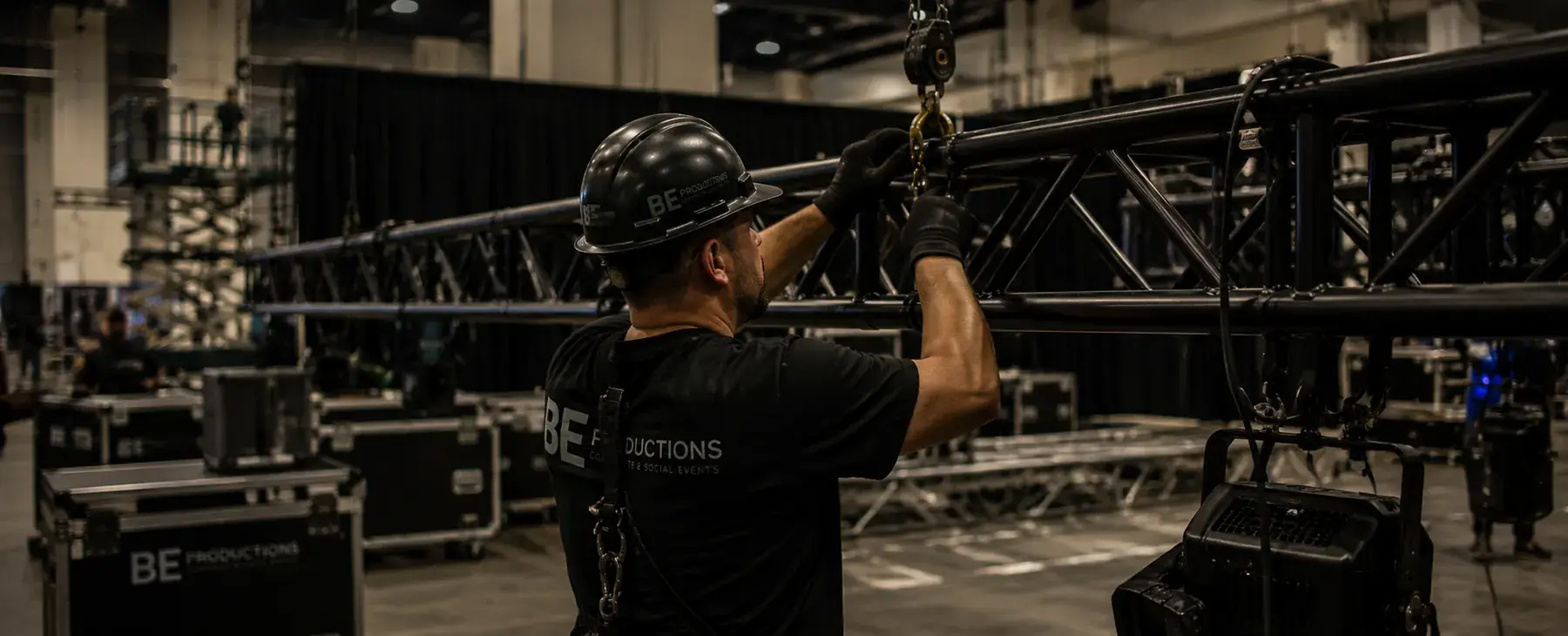 Event crew member setting up rigging and production equipment before a show