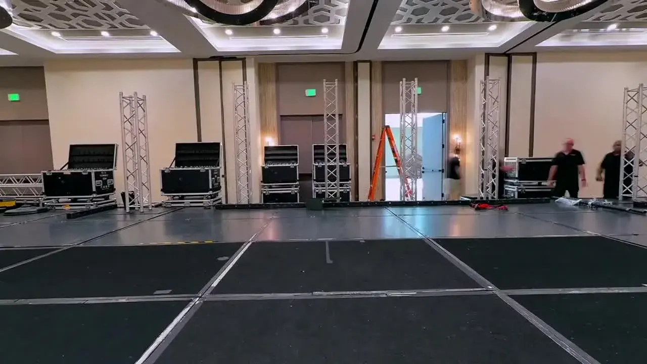 Stage platform and upright aluminum truss being assembled in an event ballroom
