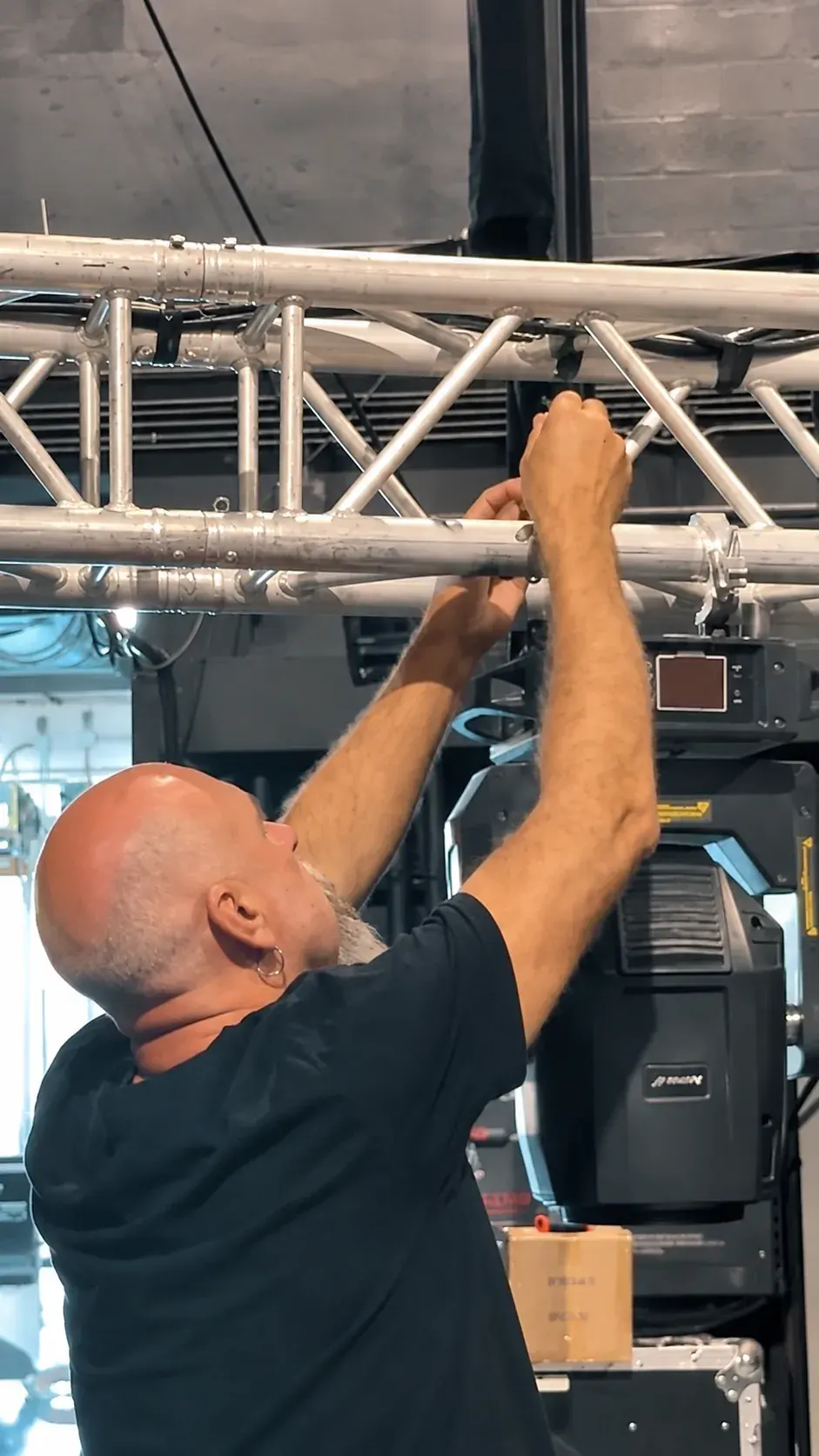 BE technician securing a lighting fixture to the event truss