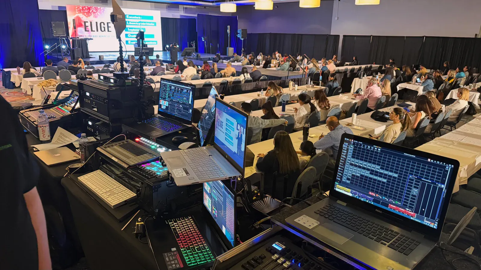 BE production desk overlooking a conference audience and illuminated stage